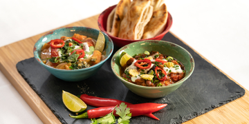 Selection of bowl food with chillies and lime, with flatbread to the side