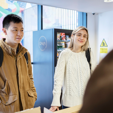two students stood at reception at Bainfield
