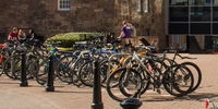 Several bikes secured to a bike rack in Merchiston campus courtyard