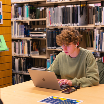 Student working on laptop in library
