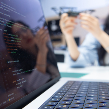 Student working with laptop in foreground