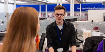 Student speaking to an Information Services staff member at the JKCC Helpdesk.