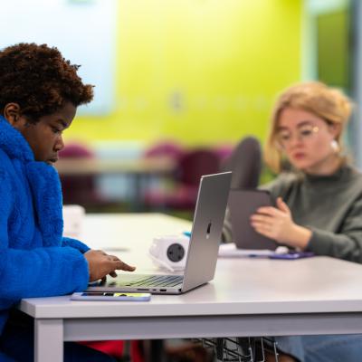 Two people using laptops and tablets