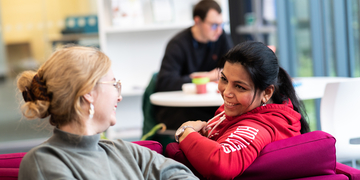Students talking over the back of a sofa at Merchiston Library