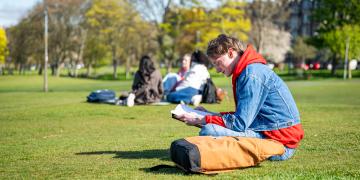 Student reading a book outside