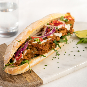 A baguette with a meat and vegetable filling