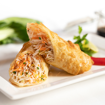Two spring rolls with noodle and carrot filling lying on white tray