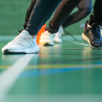Close up of trainers and sports leggings running in a gym hall