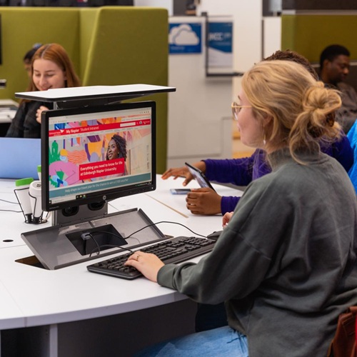 Student sitting at computer in study area accessing information online