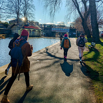 A group of students walking next to the canal path on a sunny day as part of a nature wellbeing walk