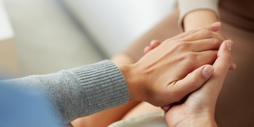 Two hands reaching out to hold and comfort each other