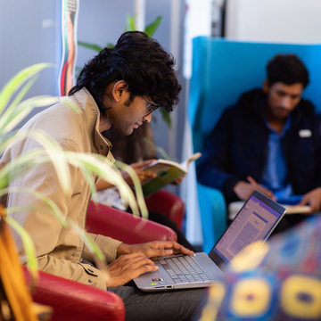 A group of students sitting in a study space, reading books