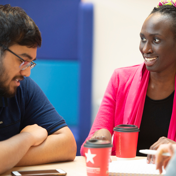 Two students studying and talking to each other