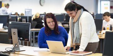Two students studying with a laptop