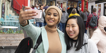 Students in Edinburgh city centre taking selfie together