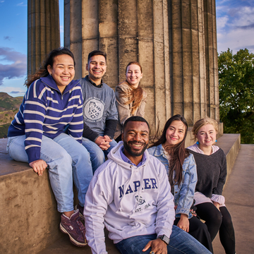 A group of international students sitting together at a monument