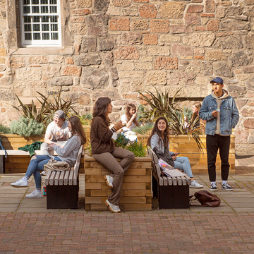 Students socialising in the sun in outdoor courtyard