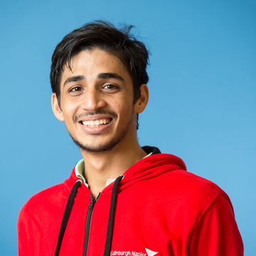 Student ambassador wearing red ambassador hoodie in front of a blue background
