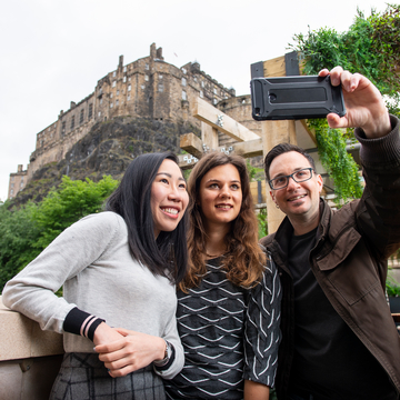 Students taking a selfie in front of Edinburgh Castle