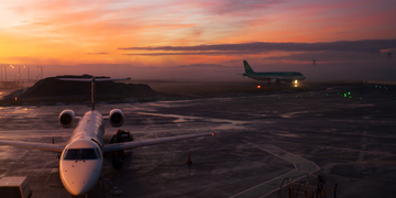 Two aeroplanes at Edinburgh Airport during sunset