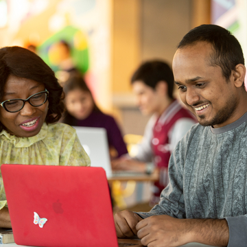 Students working on a laptop off campus