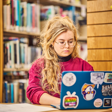 Student using a laptop in the library. 