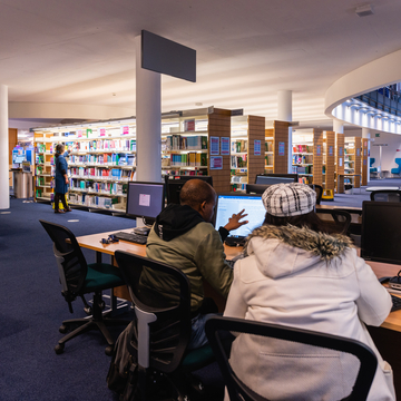 Students using computers and browsing bookshelves at Craiglockhart Library