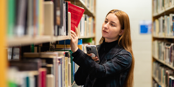 Student browsing shelves in the library
