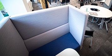 A seating both and desk in an open campus area