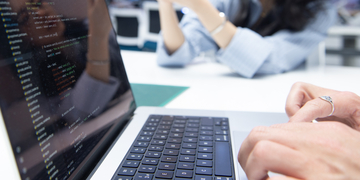 Close-up of student typing at a laptop
