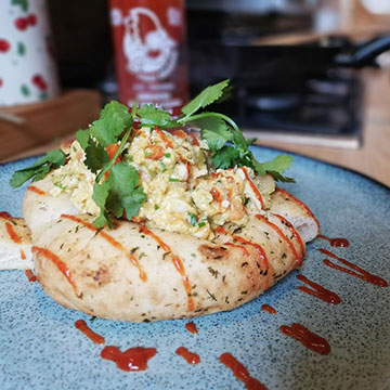Scrambled egg on homemade bread with drizzle of hot sauce