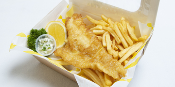 Fish and chips with garnish and lemon wedge