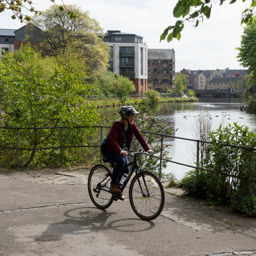 Person cycling next to canal