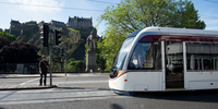 Tram travelling down Princes Street with Edinburgh Castle in the background