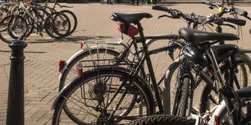 Several bikes lines up at a bike rack outside campus