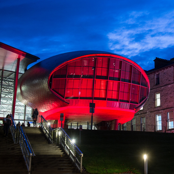 The Egg at Craiglockhart campus lit up red at night for Remembrance Day