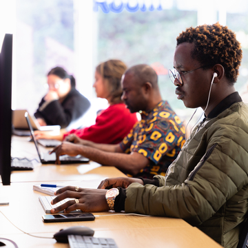 A group of students sitting at a row of computers, studying